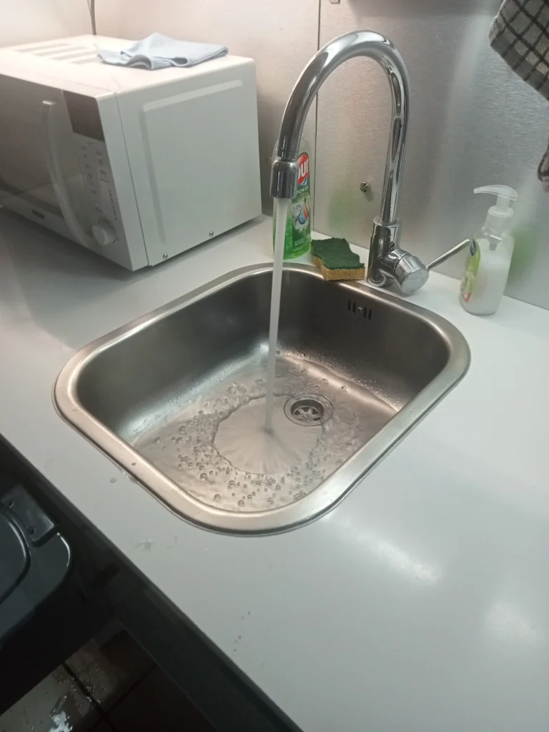 Évier de cuisine bouché avec eau stagnante en cours d’écoulement