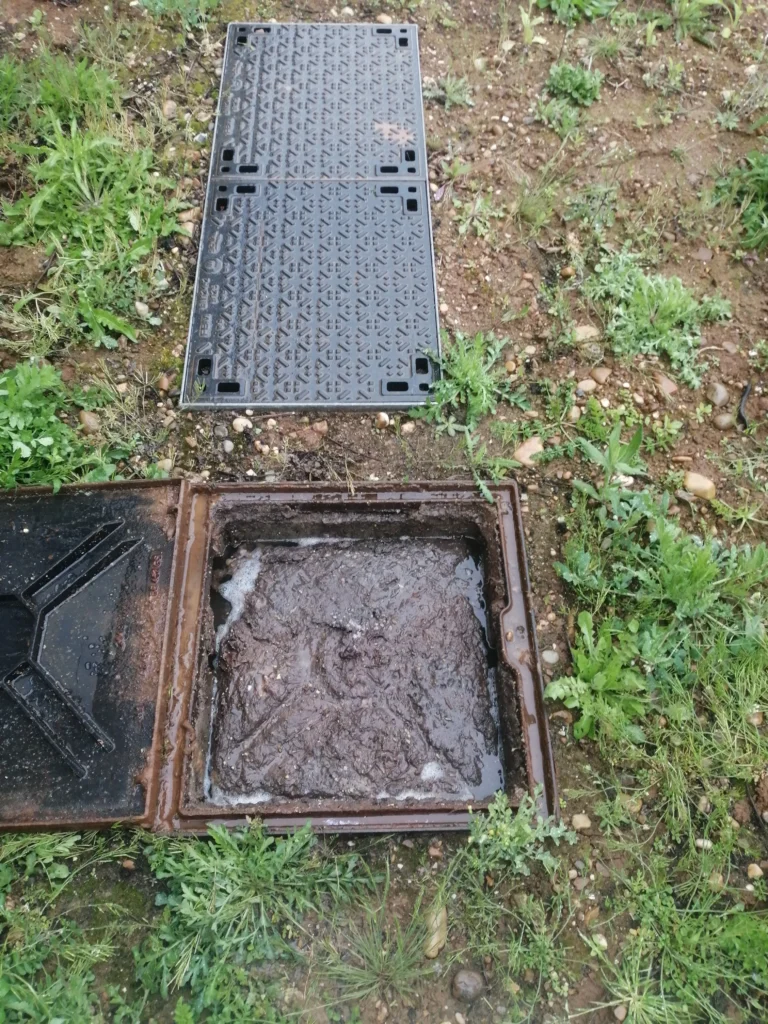 Regard de canalisation bouché avec accumulation de boues et eaux usées